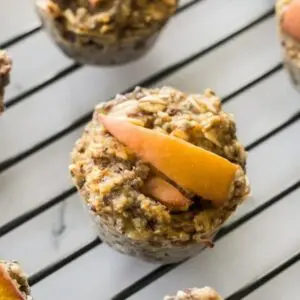 Stack of three hormone-balancing chia oatmeal cups with peach slices and berries