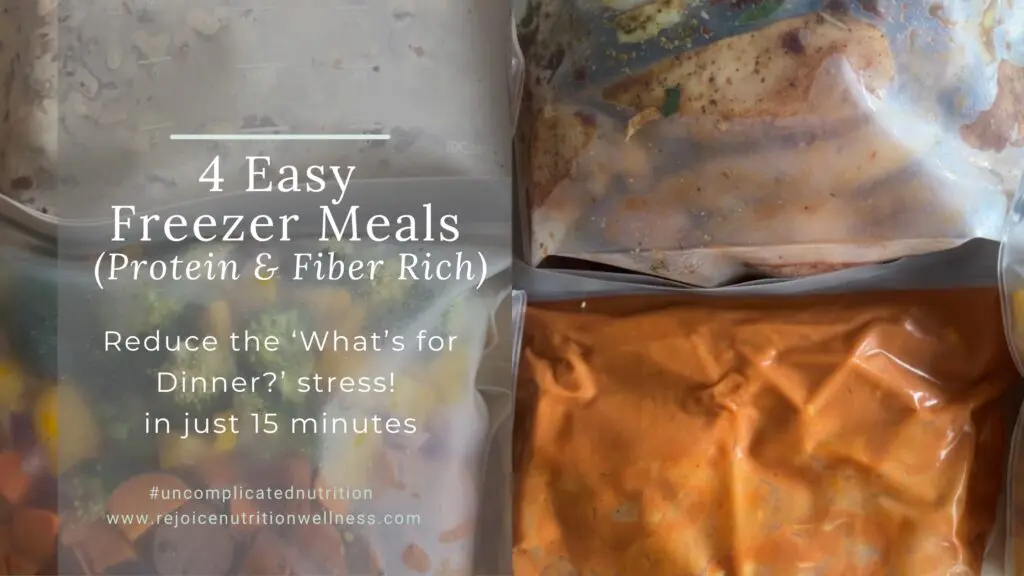 Four labeled reusable freezer bags filled with prepared ingredients for Tuscan Chicken, Butter Chicken, Beef Stroganoff, and Farmer's Sausage Bowls freezer meals