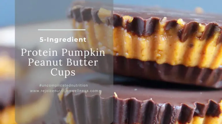 No bake protein pumpkin peanut butter cups on a white plate with dark chocolate topping and flaky sea salt