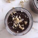 "Chocolate snickers chia pudding in glass jar topped with peanuts and dark chocolate, healthy perimenopause dessert recipe"