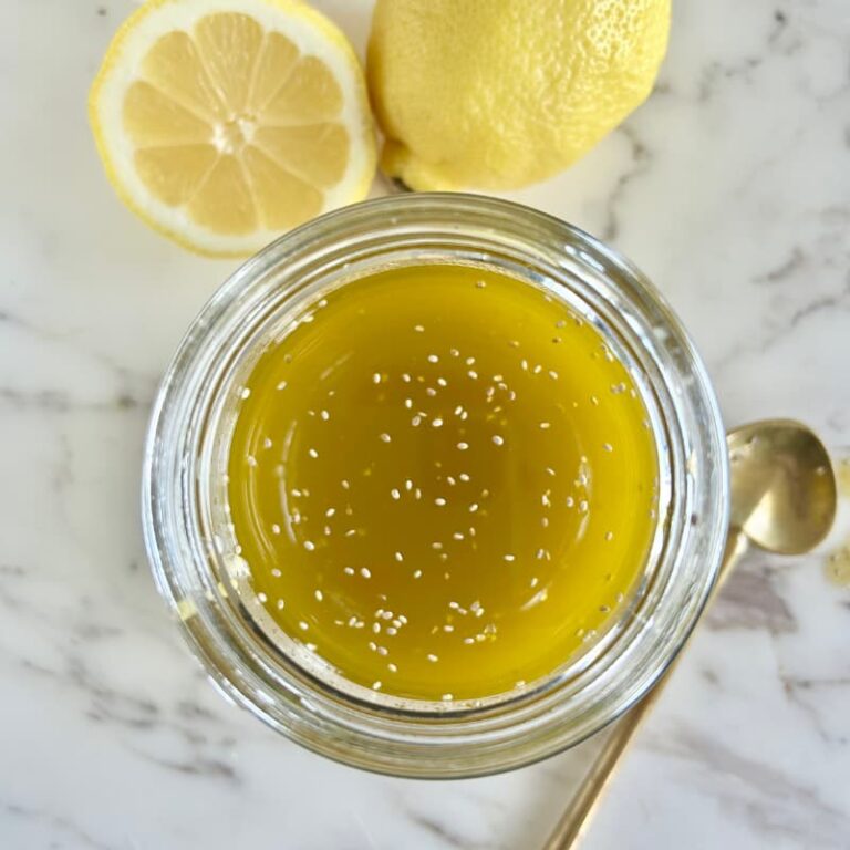 "Chia vinaigrette being drizzled over colorful summer salad with mixed greens and vegetables"