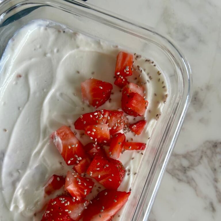Chia seeds, protein powder, fresh strawberries, and milk arranged on marble countertop for hormone-balancing breakfast recipe