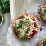 omplete cottage cheese pizza with chia seeds topped with melted cheese, fresh basil, and drizzled olive oil, ready to serve
