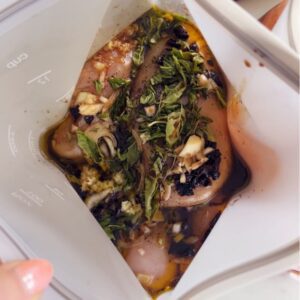 Balsamic tomato chicken marinade with sun dried tomatoes and fresh herbs in freezer bag