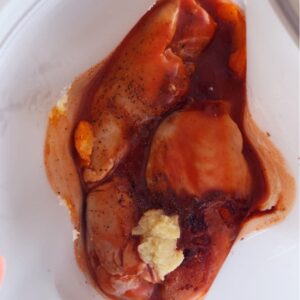 Buffalo chicken marinade in freezer bag with red sauce and spices